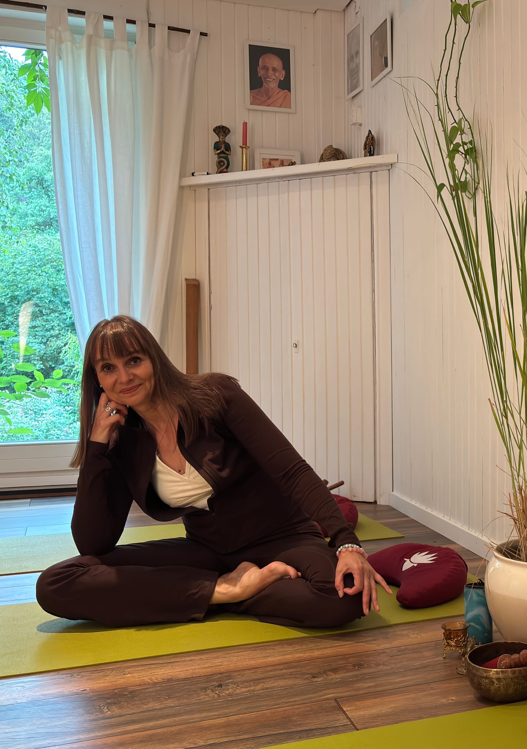 Sabine Stratmann sitzt entspannt im Schneidersitz in ihrem Yogaraum in Herdecke